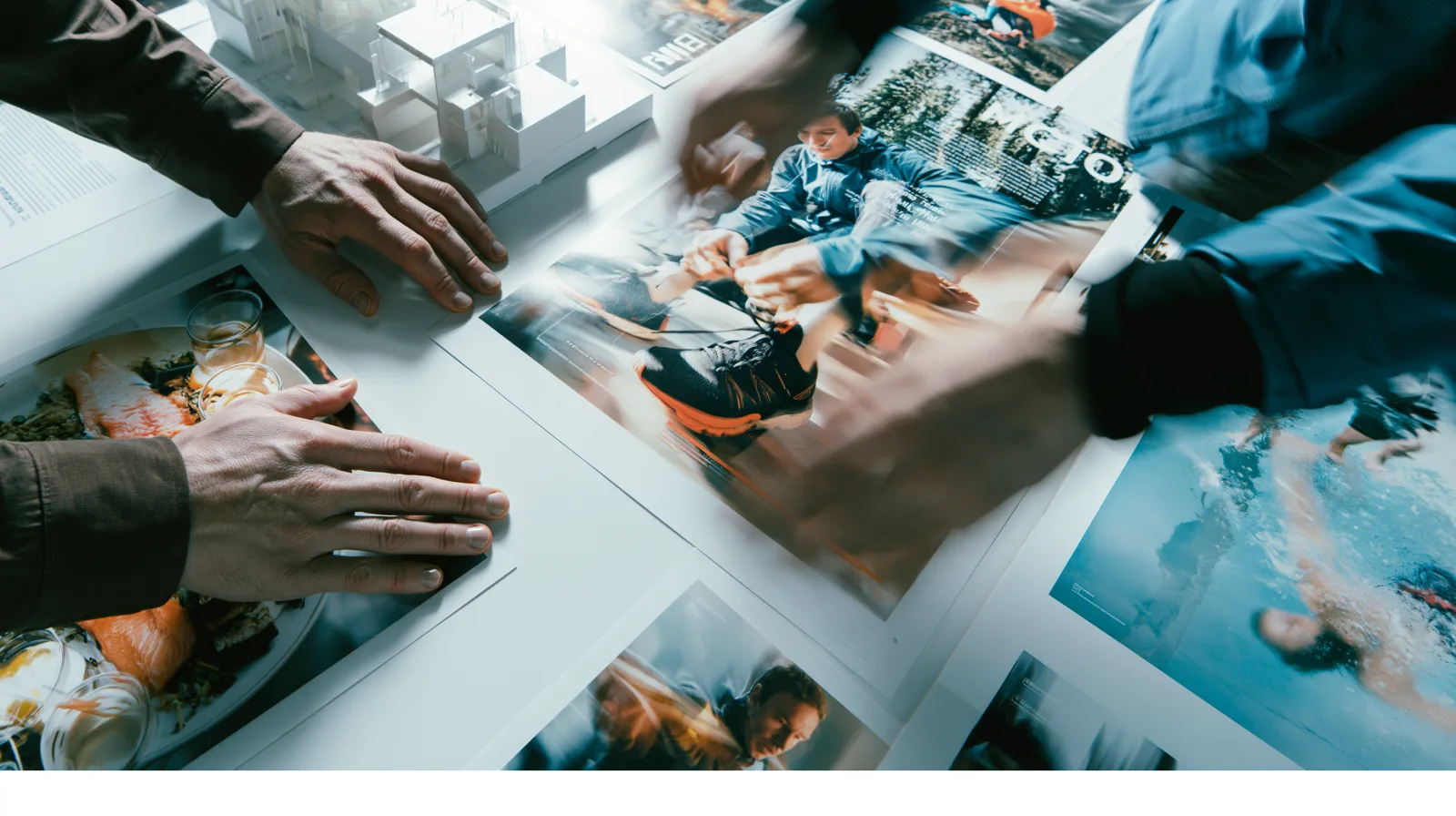 Two people reviewing printed campaign layouts across a light table